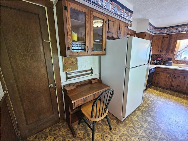 235 Mcclay Rd, Canton Twp, PA 15301 - kitchen featuring freestanding refrigerator, a textured ceiling, light floors, glass insert cabinets, and light countertops