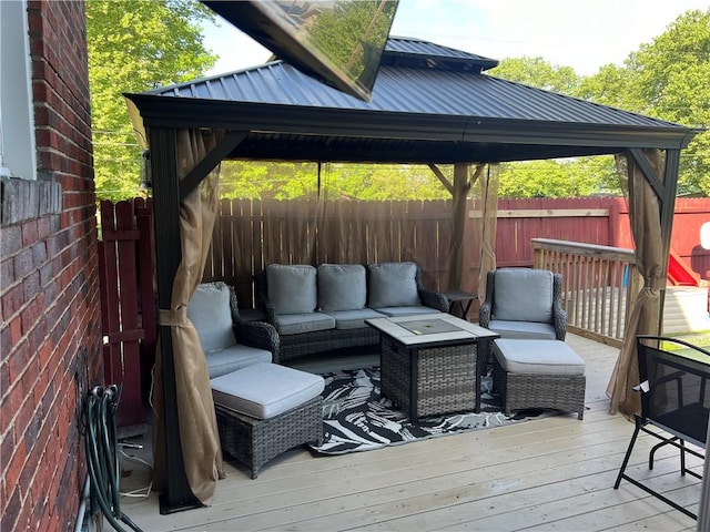 wooden terrace with an outdoor living space and a fenced backyard