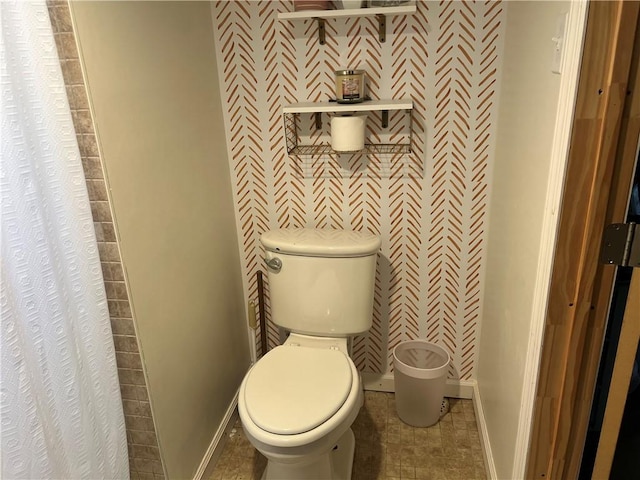 bathroom with toilet and baseboards