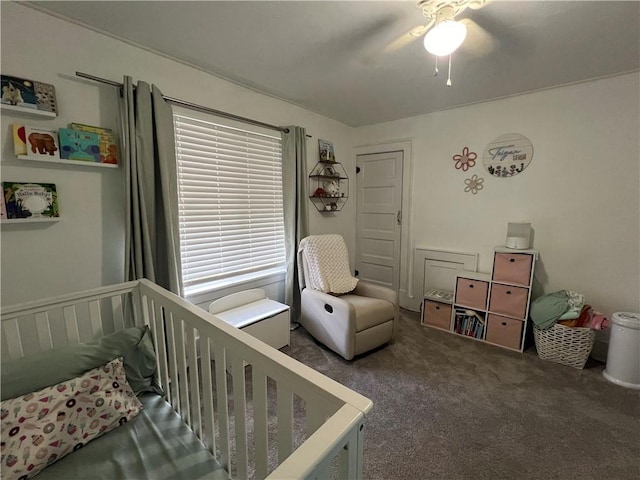 bedroom with a crib, carpet flooring, and a ceiling fan