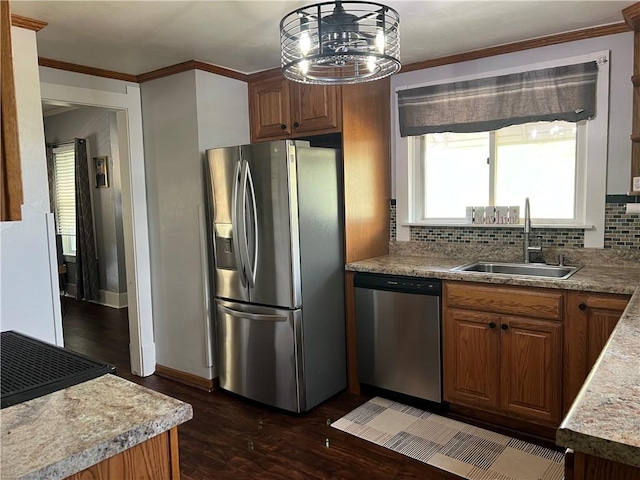 kitchen featuring appliances with stainless steel finishes, a sink, tasteful backsplash, dark wood-type flooring, and crown molding