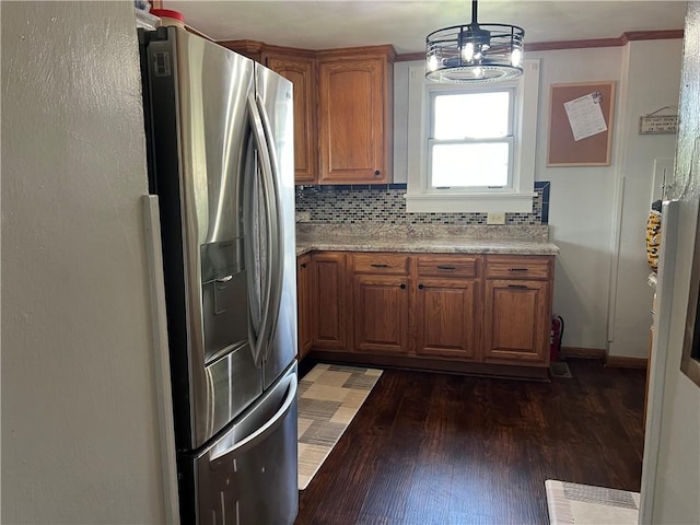 kitchen featuring stainless steel refrigerator with ice dispenser, brown cabinets, wood finished floors, tasteful backsplash, and pendant lighting