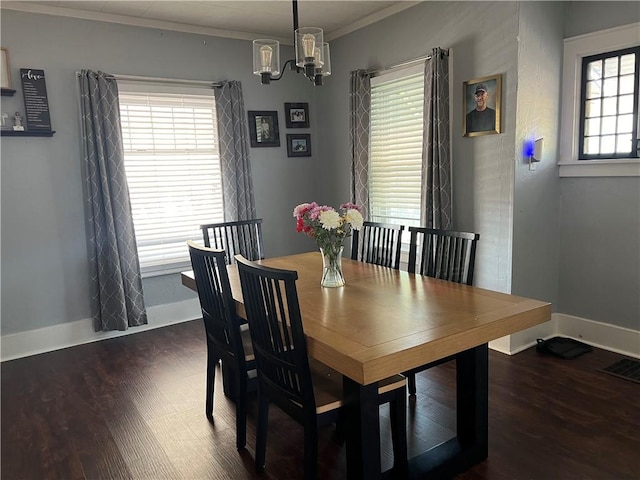 dining space featuring a chandelier, wood finished floors, crown molding, and baseboards