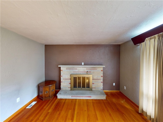 306 Cherokee Dr, Center Twp But, PA 16001 - unfurnished living room featuring wood finished floors, a fireplace, a textured wall, baseboards, and a textured ceiling