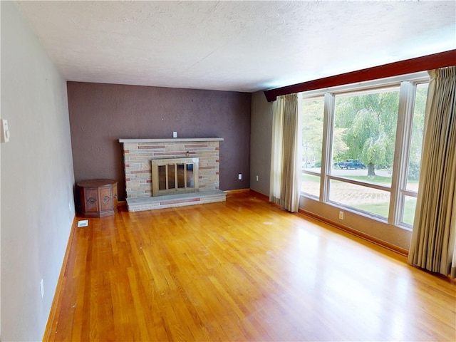 306 Cherokee Dr, Center Twp But, PA 16001 - unfurnished living room featuring light wood-style flooring, a stone fireplace, and baseboards