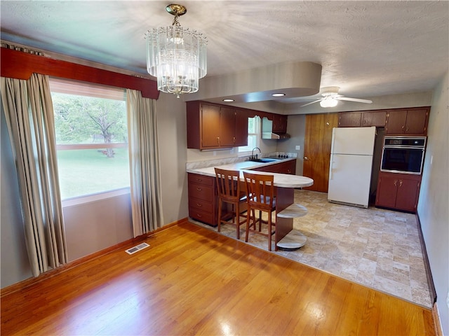 306 Cherokee Dr, Center Twp But, PA 16001 - kitchen featuring freestanding refrigerator, black oven, a peninsula, a ceiling fan, and light countertops