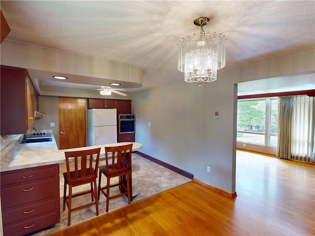 306 Cherokee Dr, Center Twp But, PA 16001 - kitchen featuring freestanding refrigerator, black oven, light wood-style floors, a ceiling fan, and a chandelier