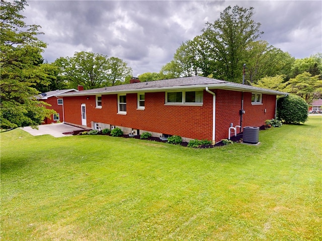 306 Cherokee Dr, Center Twp But, PA 16001 - view of home's exterior with a chimney, a patio area, a lawn, and brick siding