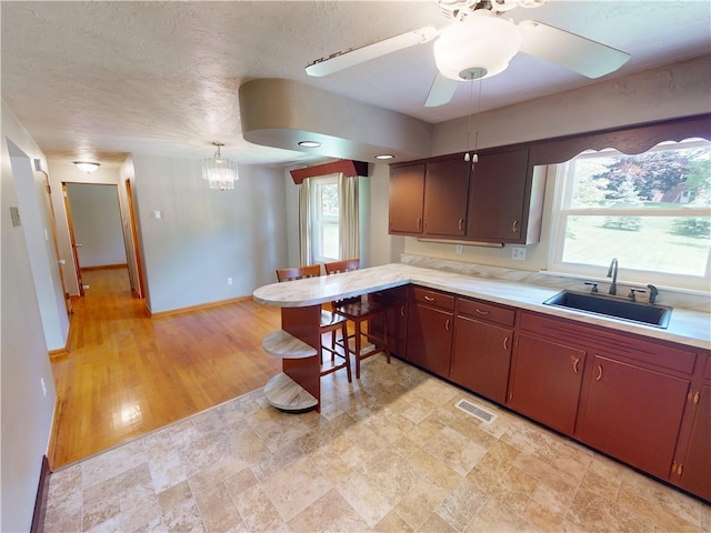 306 Cherokee Dr, Center Twp But, PA 16001 - kitchen featuring a sink, light countertops, a peninsula, a ceiling fan, and a textured ceiling