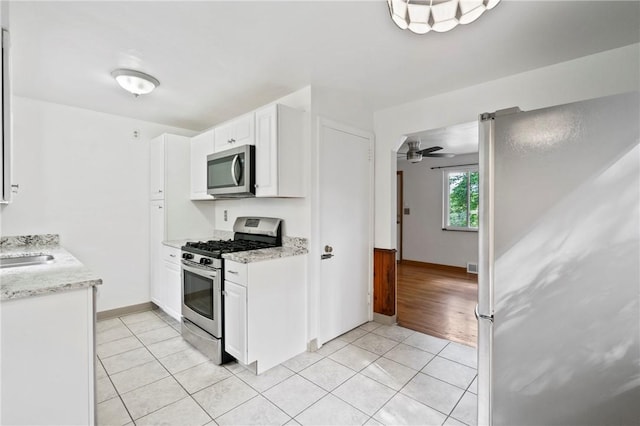 119 Hillcrest Dr, Ross Twp, PA 15237 - kitchen with stainless steel appliances, white cabinets, light tile patterned floors, a ceiling fan, and light stone counters