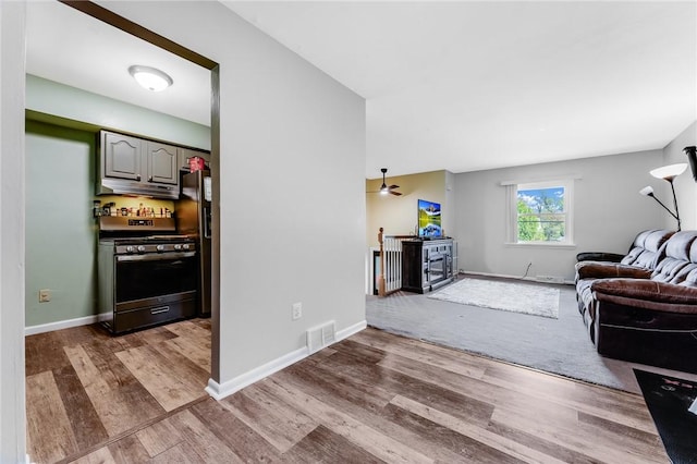 118 Arrow Dr, Elizabeth Twp/Boro, PA 15037 - living room featuring wood finished floors, baseboards, a wood stove, and a ceiling fan