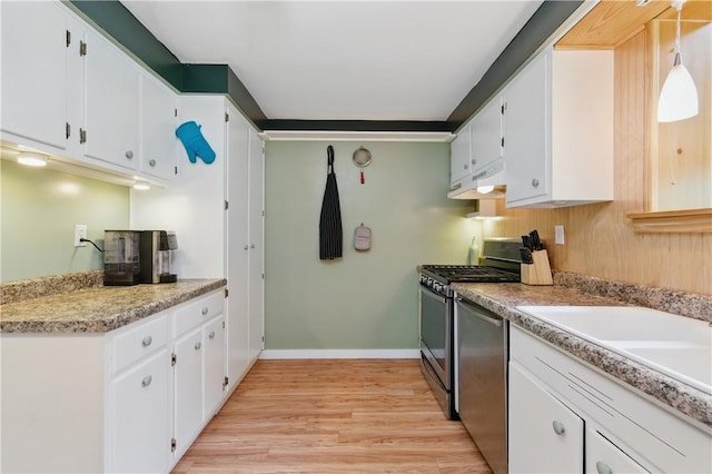 156 Carnation Ave, Ross Twp, PA 15229 - kitchen with under cabinet range hood, appliances with stainless steel finishes, light wood finished floors, and white cabinets