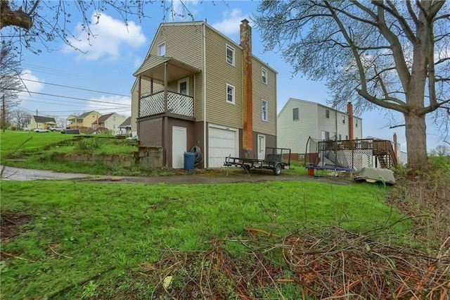 622 Ascension Dr, West Mifflin, PA 15122 - back of property featuring a trampoline, a garage, a chimney, and a lawn
