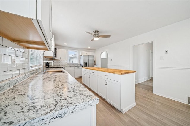 1422 Meadow St, Mckeesport, PA 15132 - kitchen with stainless steel fridge, wooden counters, a ceiling fan, light wood-style floors, and white cabinets