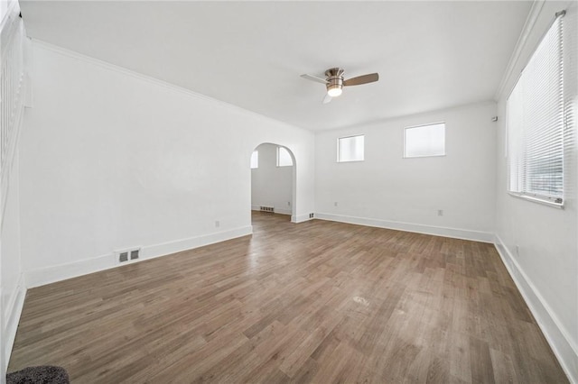 1422 Meadow St, Mckeesport, PA 15132 - spare room featuring arched walkways, a ceiling fan, wood finished floors, ornamental molding, and baseboards
