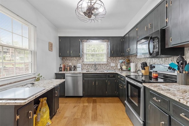 830 W Pike St, Chartiers, PA 15342 - kitchen featuring appliances with stainless steel finishes, light wood finished floors, backsplash, a sink, and light stone countertops