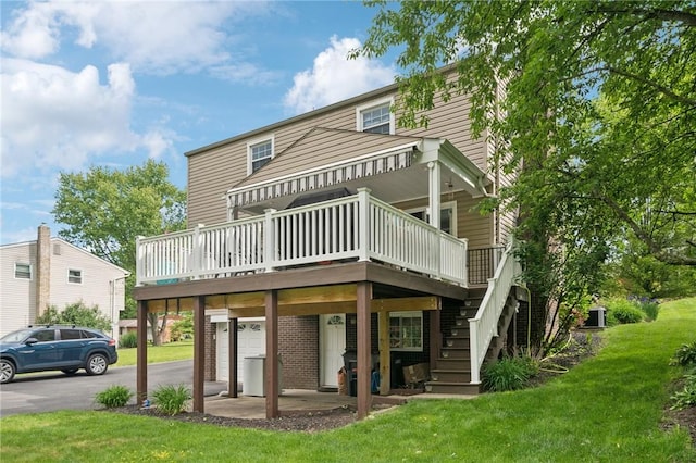 282 Carmell Dr, Upper St Clair, PA 15241 - back of property with a wooden deck, a yard, asphalt driveway, a garage, and brick siding