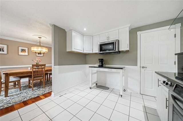 282 Carmell Dr, Upper St Clair, PA 15241 - kitchen with stainless steel microwave, white cabinetry, a wainscoted wall, crown molding, and a textured ceiling