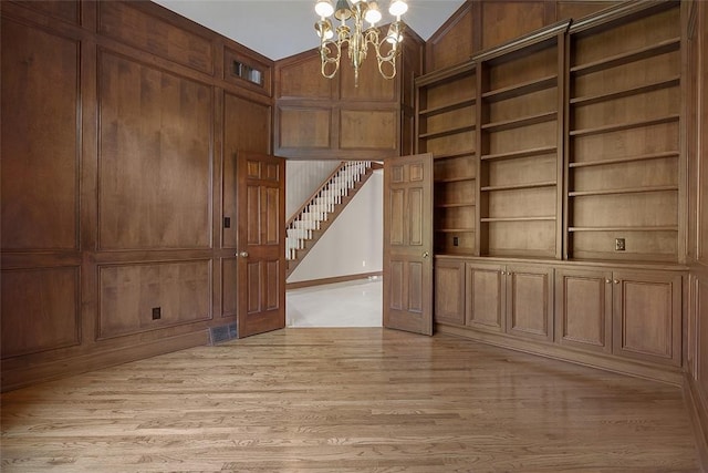 3702 Millstone Ct, Murrysville, PA 15668 - spare room featuring a chandelier, light wood-type flooring, stairway, built in features, and baseboards