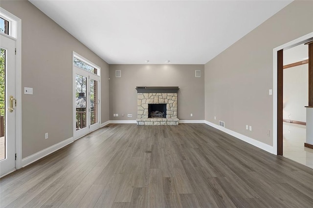 3702 Millstone Ct, Murrysville, PA 15668 - unfurnished living room featuring wood finished floors, a stone fireplace, and baseboards