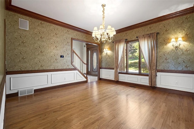 3702 Millstone Ct, Murrysville, PA 15668 - unfurnished room with a chandelier, wallpapered walls, stairs, a wainscoted wall, and wood finished floors