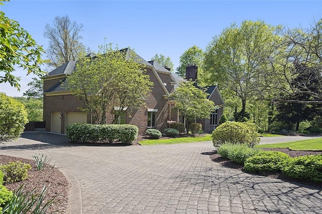 3702 Millstone Ct, Murrysville, PA 15668 - view of front of house featuring asphalt driveway, brick siding, a garage, and a chimney