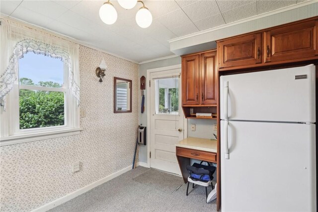 211 Homestead Dr, Middlesex Twp, PA 16059 - kitchen featuring freestanding refrigerator, light colored carpet, brown cabinetry, ornamental molding, and light countertops