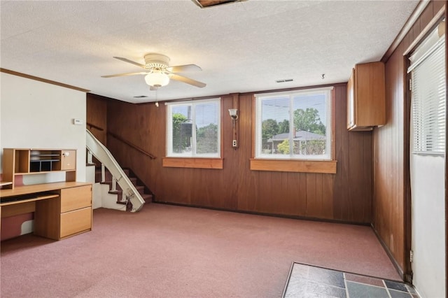 211 Homestead Dr, Middlesex Twp, PA 16059 - empty room featuring light carpet, wooden walls, stairway, a ceiling fan, and a textured ceiling
