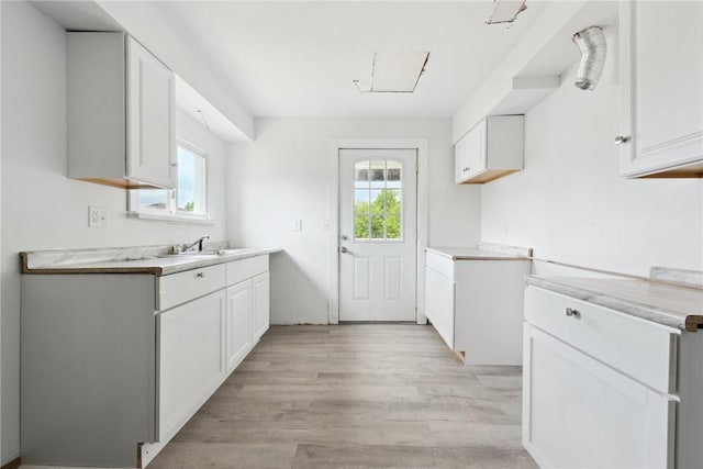 920 W 4th Ave, Derry Twp, PA 15627 - kitchen with light wood-style floors, light countertops, white cabinets, and a sink
