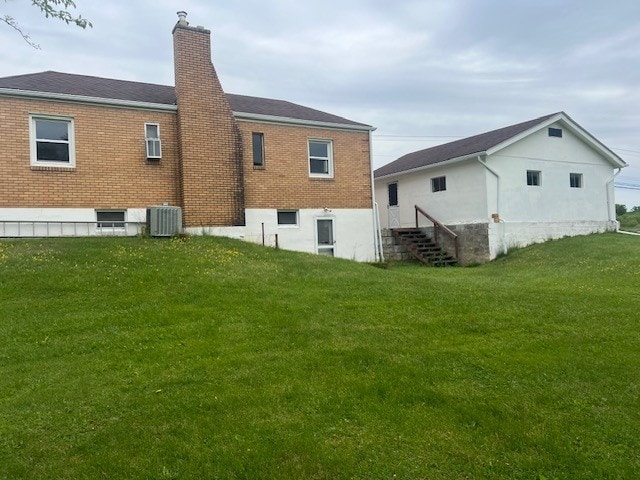 525 Glade Mill Run, Middlesex Twp, PA 16059 - back of house with central AC, a chimney, brick siding, and a lawn
