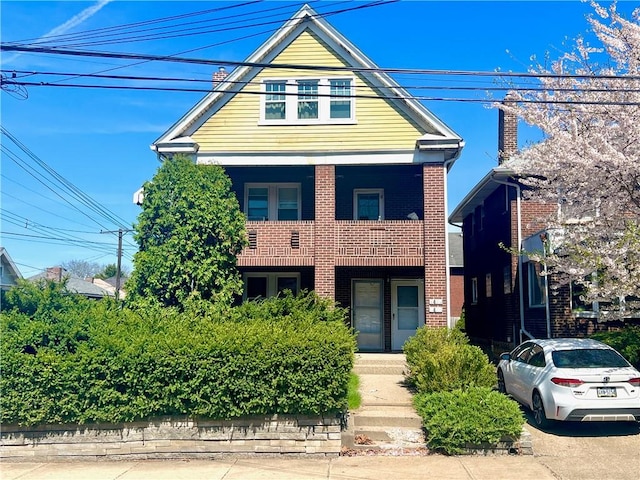 7437-7439 Schoyer Ave, Swissvale, PA 15218 - view of front of house with brick siding, a balcony, and covered porch