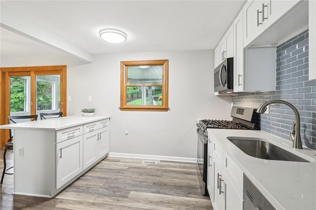 362 Fruitwood Dr, Bethel Park, PA 15102 - kitchen with stainless steel appliances, a sink, a peninsula, a kitchen breakfast bar, and backsplash
