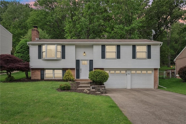 362 Fruitwood Dr, Bethel Park, PA 15102 - split foyer home featuring an attached garage, brick siding, a chimney, concrete driveway, and a lawn