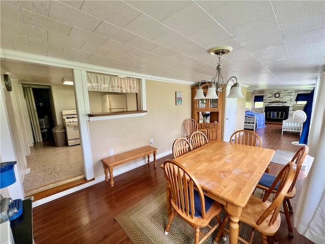 11859 Kammerer Ave, Conneaut Lake Cra, PA 16316 - dining area with wood finished floors, baseboards, a fireplace, and crown molding