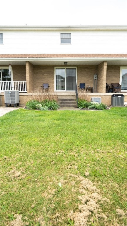 4895 Lucerne Rd, White Twp Ind, PA 15701 - back of house featuring central AC, brick siding, and a lawn