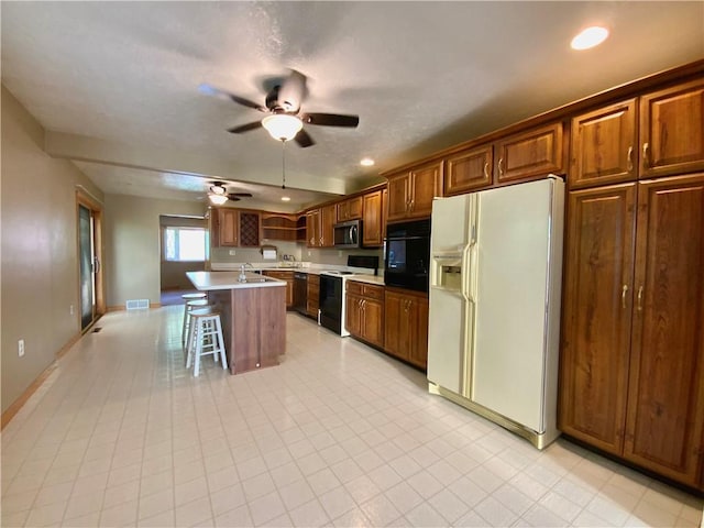 403 Virginia Ave, Harmony Twp Bea, PA 15003 - kitchen featuring black appliances, ceiling fan, a kitchen bar, light countertops, and recessed lighting