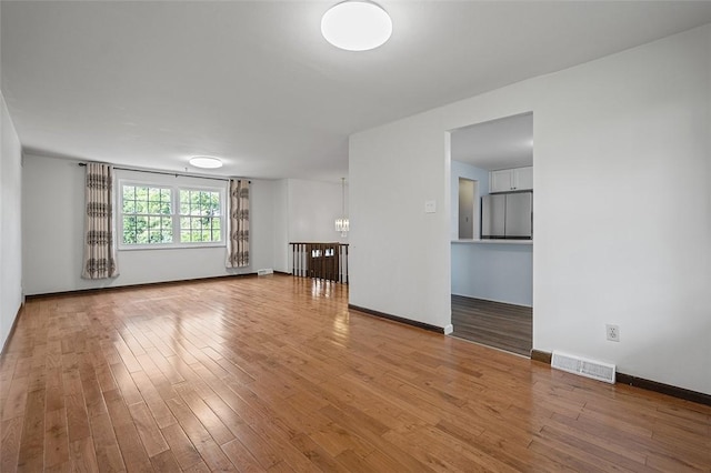 440 Perrymont, Mccandless, PA 15237 - unfurnished living room featuring wood finished floors, a chandelier, and baseboards