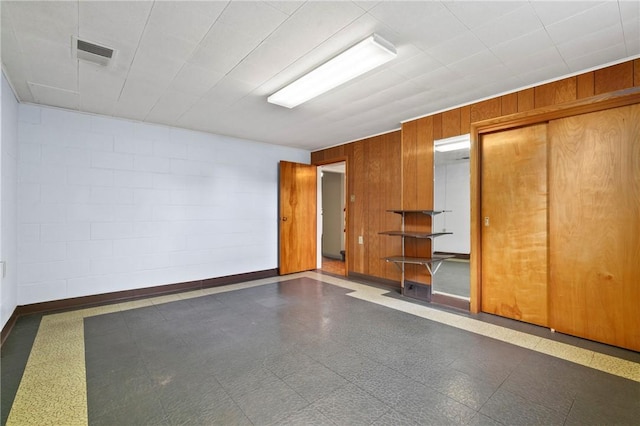 128 Wise Rd, City Of But Se, PA 16002 - empty room featuring tile patterned floors, baseboards, and wood walls
