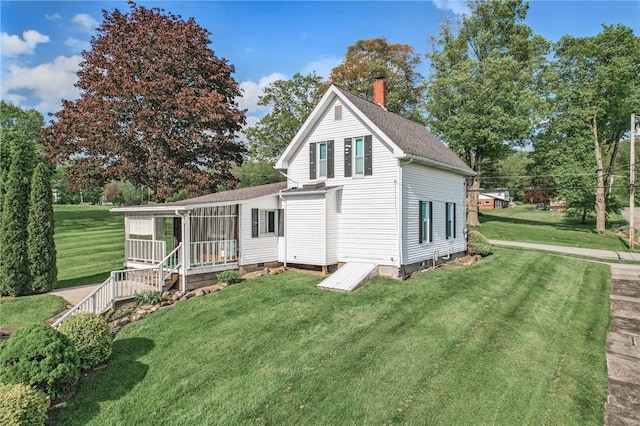 601 Depot St, Jamestown, PA 16134 - view of front of house with a chimney, a front yard, a sunroom, and roof with shingles