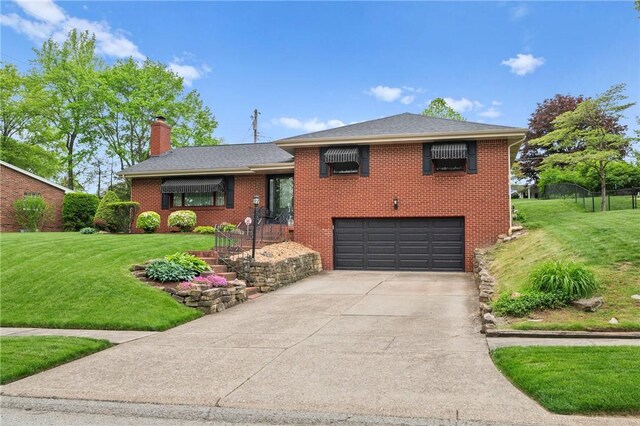 244 Elmtree Rd, New Kensington, PA 15068 - split level home with a garage, a front yard, concrete driveway, a chimney, and brick siding