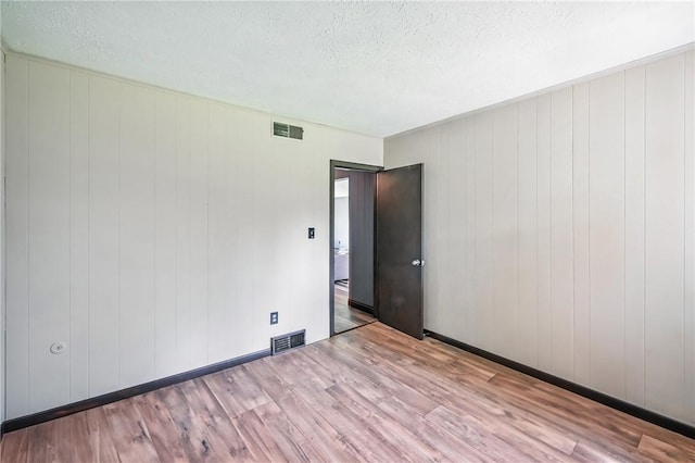 13035 State Highway 618, Conneaut Lake Cra, PA 16316 - unfurnished room with wood finished floors, a textured ceiling, and baseboards