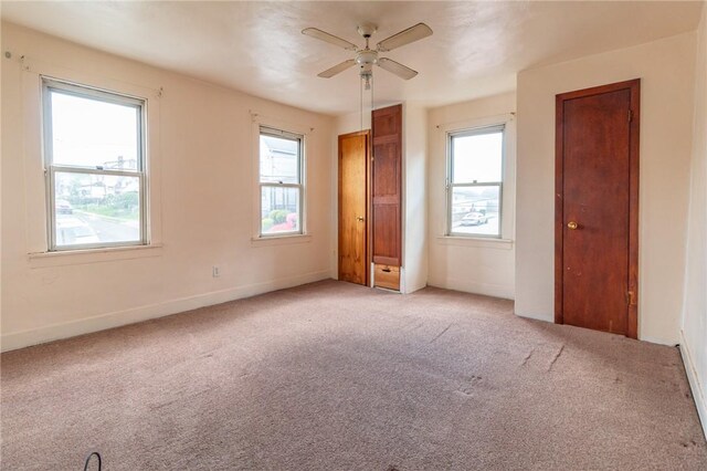 2605 Fayette St, Mckeesport, PA 15132 - unfurnished bedroom featuring light colored carpet, baseboards, two closets, and ceiling fan