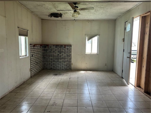 227 Woodlands Rd, Connoquenessing Twp, PA 16033 - empty room with healthy amount of natural light, a ceiling fan, and light tile patterned floors