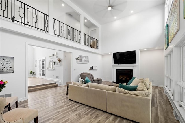 323 Snowberry Cir, Peters Twp, PA 15367 - living room with a towering ceiling, a ceiling fan, a fireplace, wood finished floors, and recessed lighting