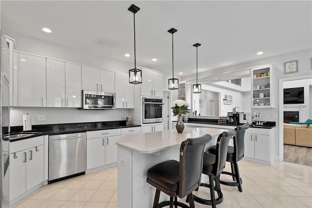 323 Snowberry Cir, Peters Twp, PA 15367 - kitchen featuring appliances with stainless steel finishes, white cabinetry, a center island, a breakfast bar, and light tile patterned flooring