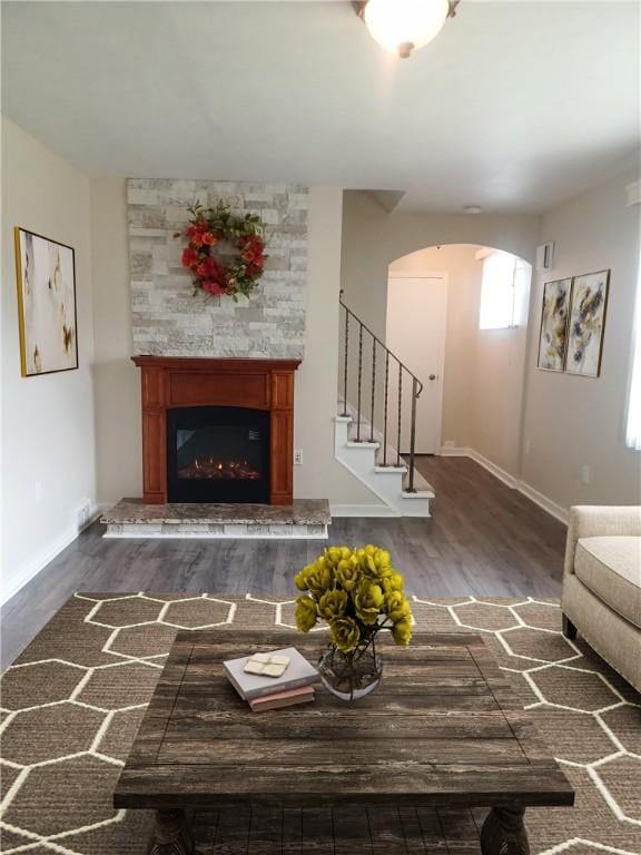 507 Bon Air Rd, Penn Hills, PA 15235 - living area featuring arched walkways, dark wood finished floors, a glass covered fireplace, baseboards, and stairway