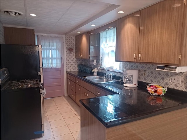 507 Bon Air Rd, Penn Hills, PA 15235 - kitchen featuring stainless steel gas range, a sink, light tile patterned floors, recessed lighting, and a peninsula