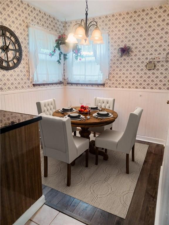 507 Bon Air Rd, Penn Hills, PA 15235 - dining area featuring wallpapered walls, a wainscoted wall, a chandelier, healthy amount of natural light, and wood finished floors
