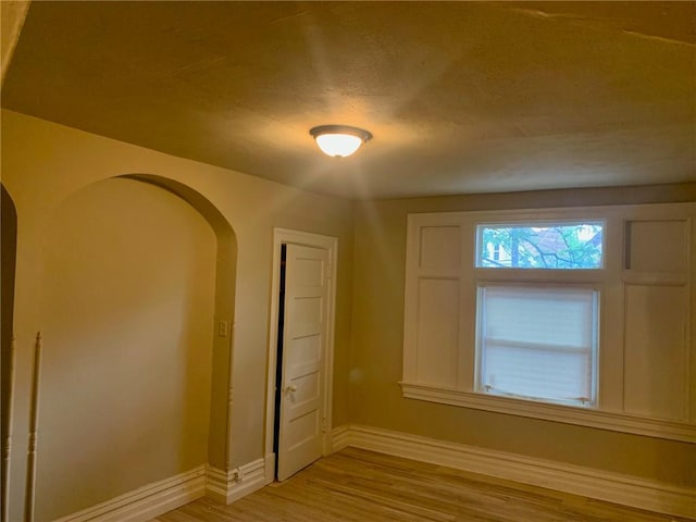 601 N Ave, Wilkinsburg, PA 15221 - empty room with baseboards, light wood finished floors, and arched walkways