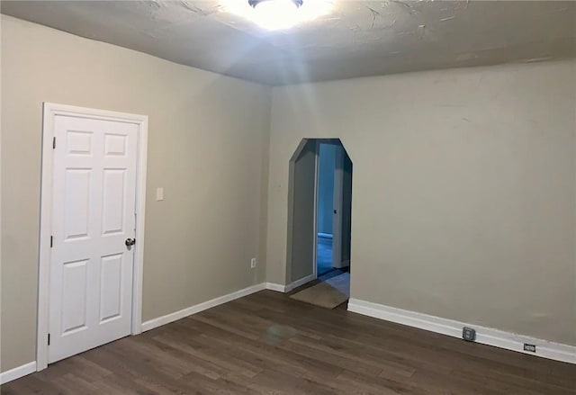 601 N Ave, Wilkinsburg, PA 15221 - unfurnished room with arched walkways, dark wood-style flooring, and baseboards